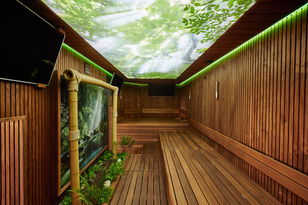 Plameco spanplafonds: sauna met van achter verlicht fotoplafond in bosmotief