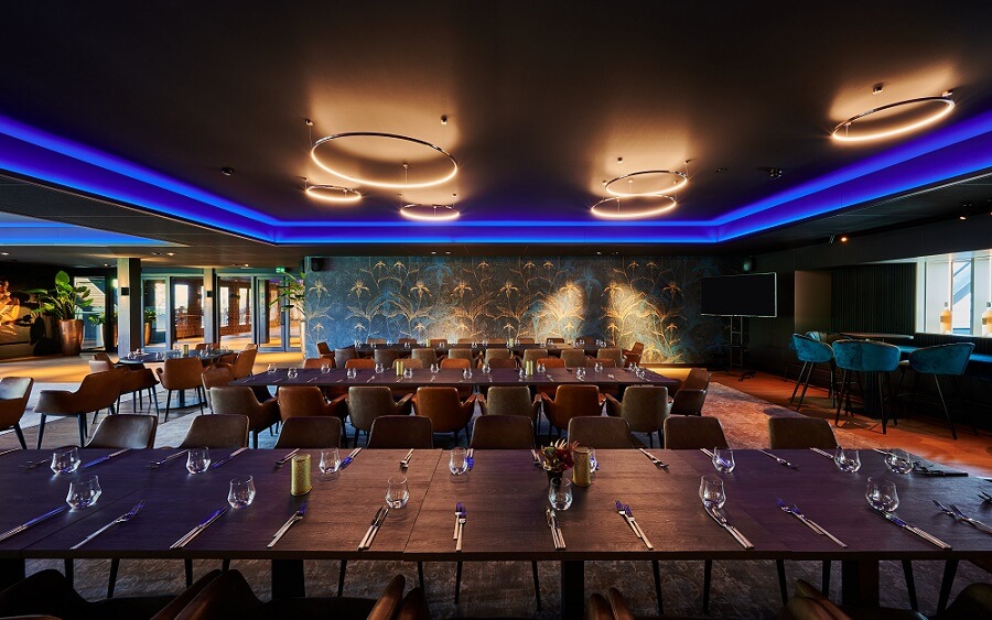 Mat zwart Plameco spanplafond boven eetzaal van restaurant met blauwe indirecte ledverlichting rondom