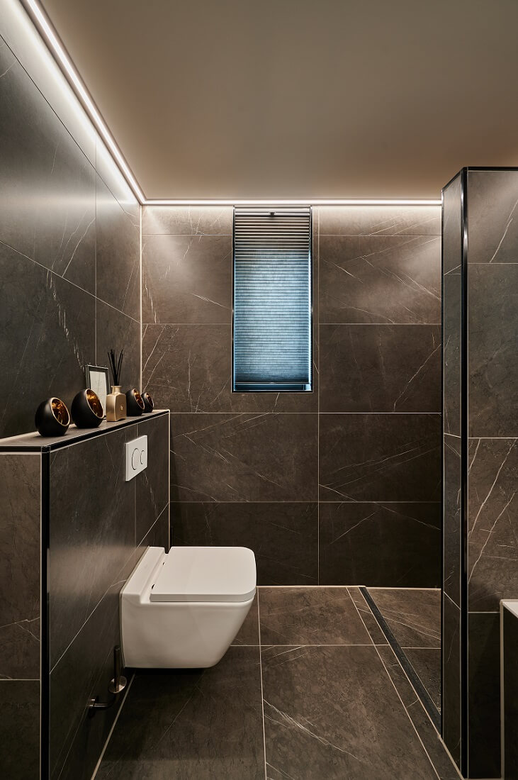 Vochtbestendig Plameco spanplafond in de badkamer met warm-witte RGBWW-verlichting in een led-strip rondom de ruimte
