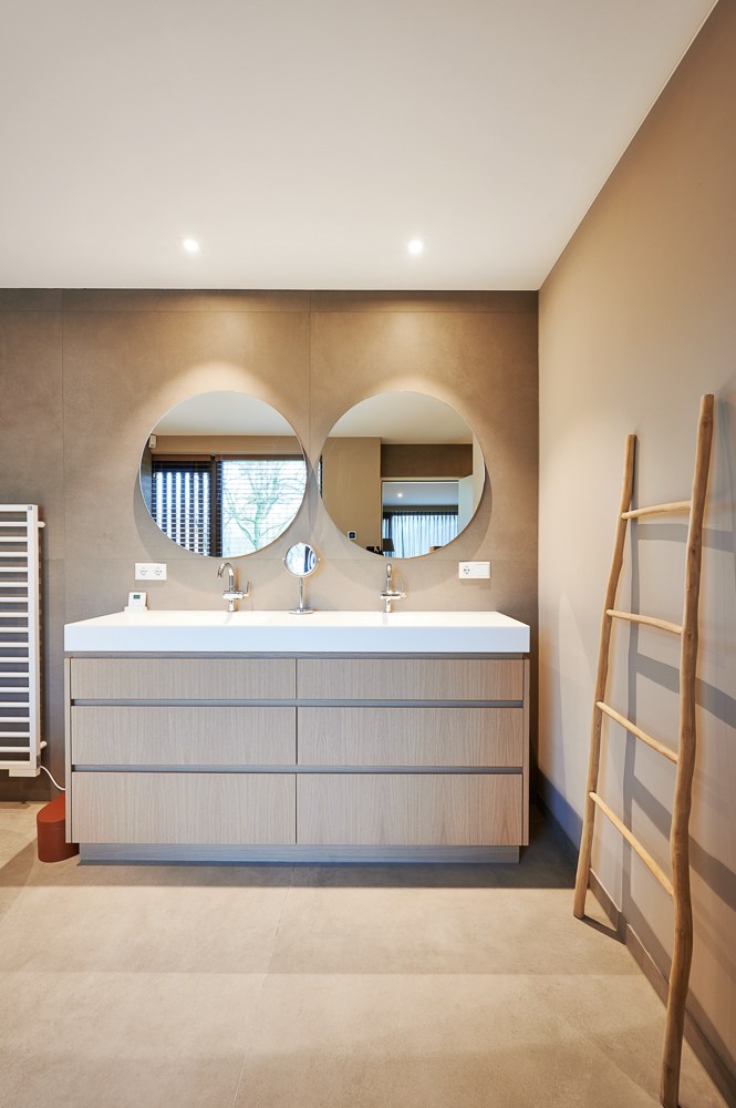 Vochtbestendig spanplafond in badkamer met inbouwspots boven wastafel met twee kranen