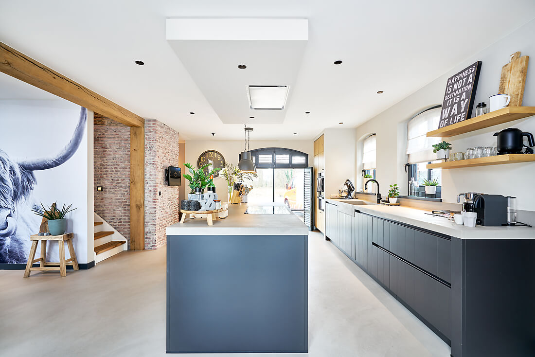 Mat wit plameco spanplafond in landelijke keuken met ingebouwde afzuigkap en houten balken.